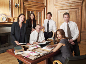 Lawyers around desk in office